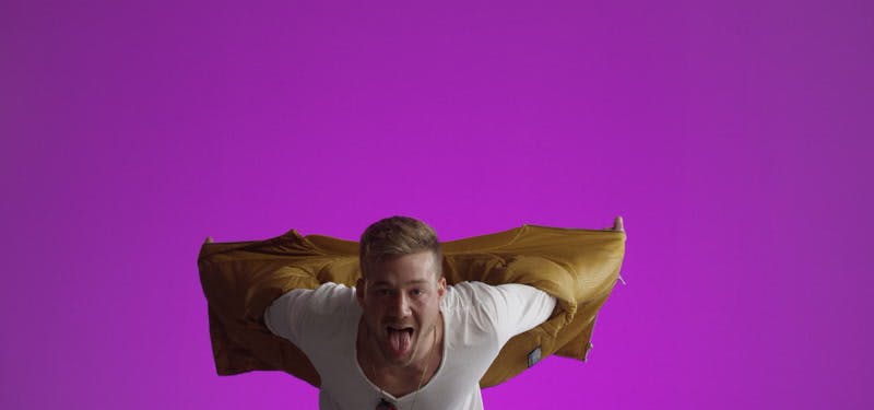 male model tacking off his jacket while showing his tongue