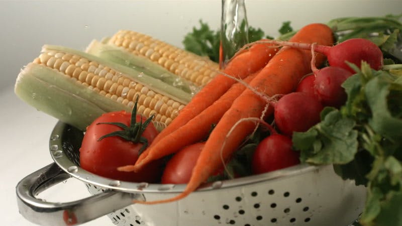 vegetables getting washed in a colander 