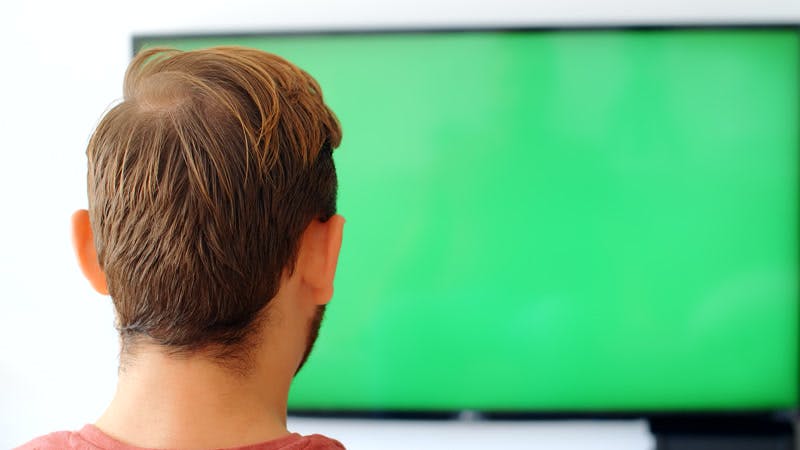 man watching a TV and cheering green screen
