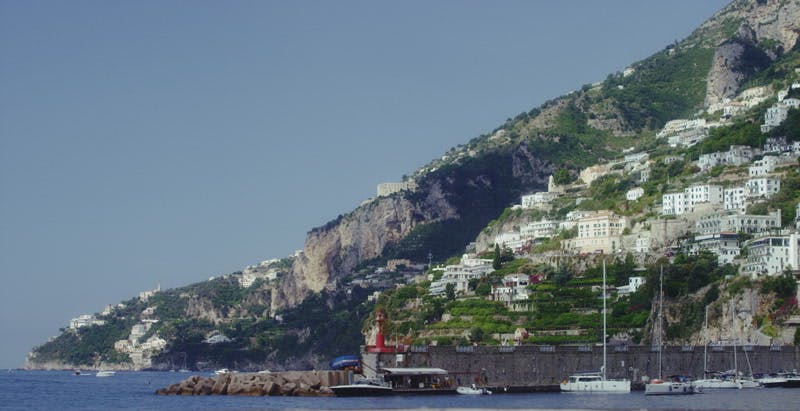 village on mountainside by ocean