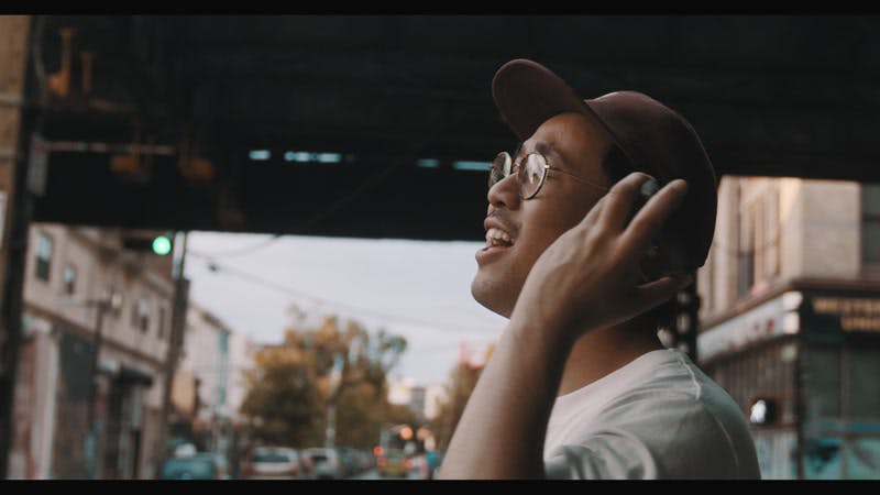 man listening to music on cellphone and singing in city streets