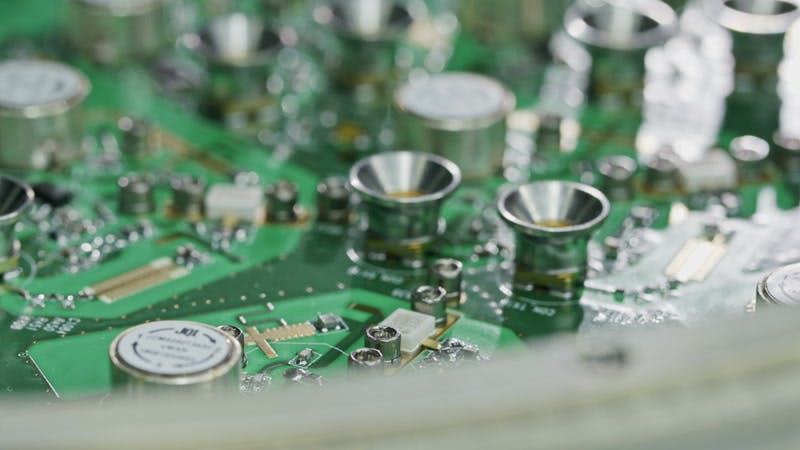 person soldering transistors on a circuit board