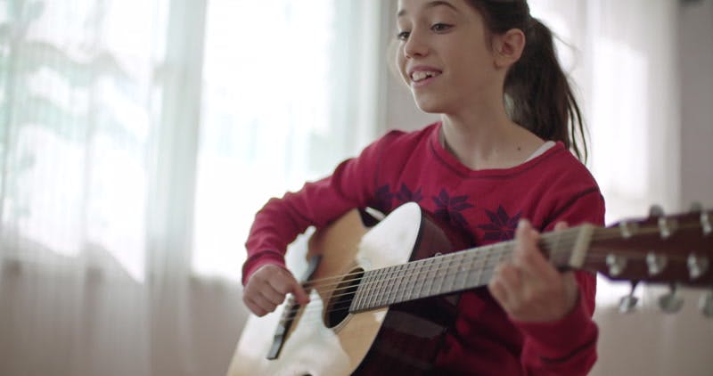girl singing while playing the guitar 