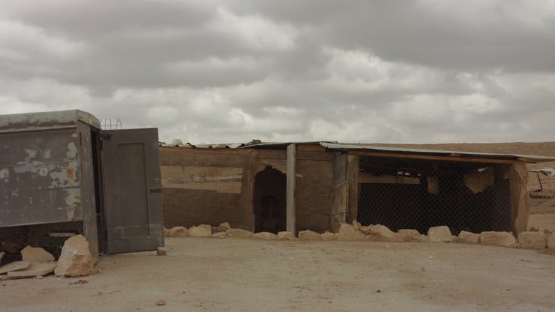 wooden shacks in desert on cloudy day