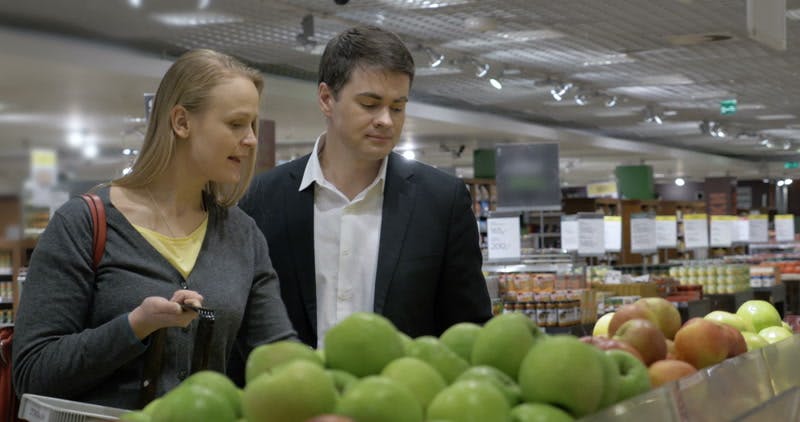 couple smelling apples in the supermarket 