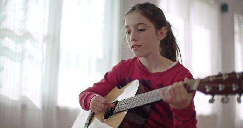 girl playing the guitar and singing 