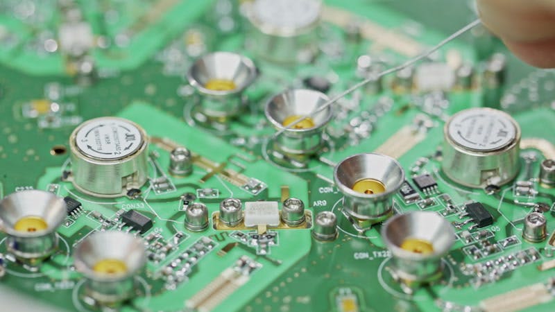 person soldering a circuit board with solder and resin 