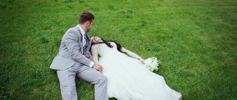 bride and groom relaxing on the grass together
