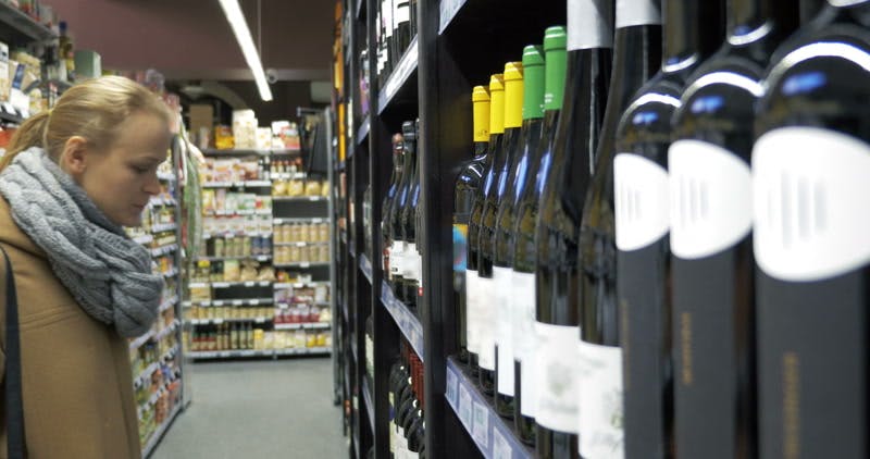woman choosing wine in the supermarket