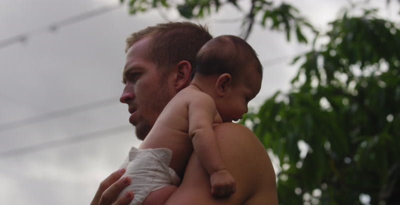 father holds baby over shoulder and soothes him gently