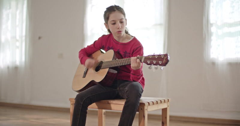 girl playing guitar and singing 