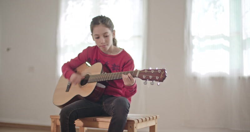 girl singing and playing on the guitar