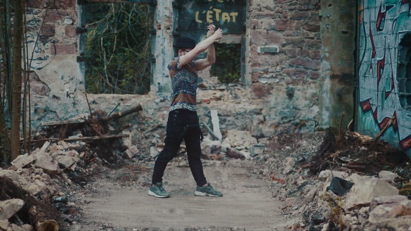 man dancing in between rubble in abandoned building