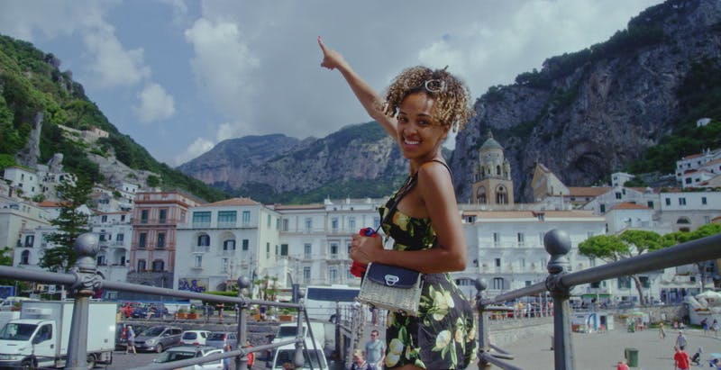 woman pointing at mountain while smiling at camera