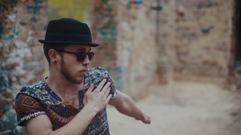 man wearing hat dancing in abandoned building