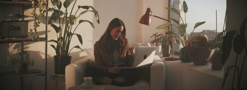 woman waving to someone on a video call 