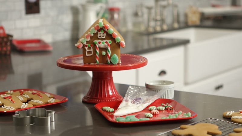 gingerbread house and cookies on a kitchen counter