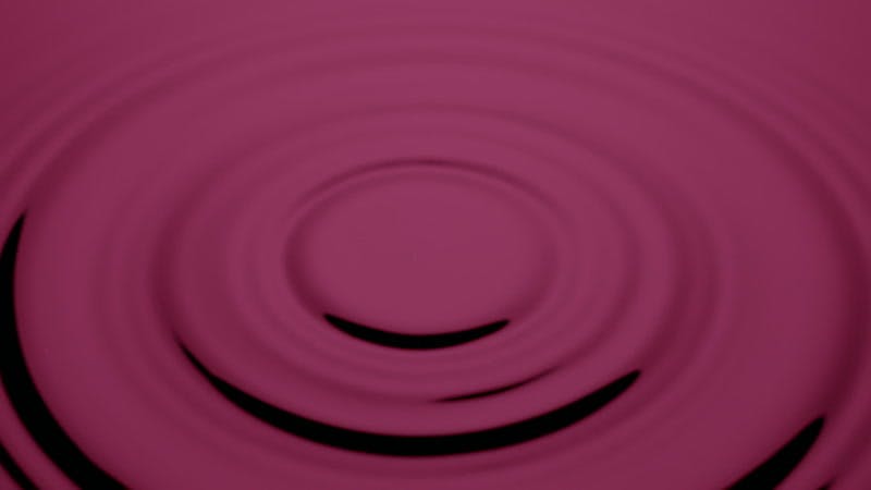 drop of water falling onto a pink wet surface
