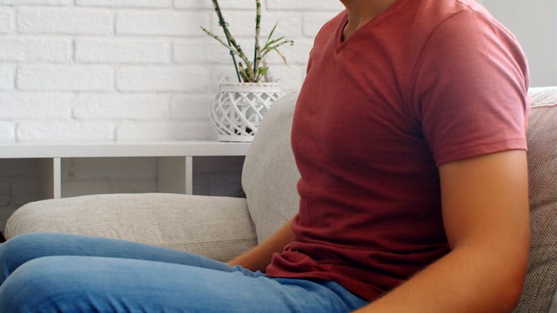 man sitting on a couch making a triumphant gesture