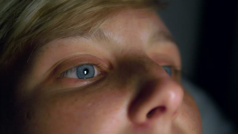 light reflecting off a woman's face in the dark