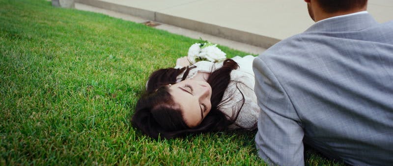 bride and groom lying on the grass together