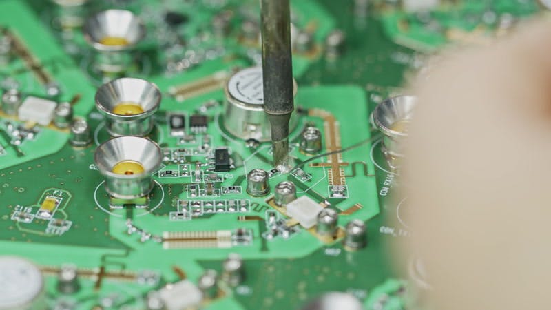 person soldering a circuit board