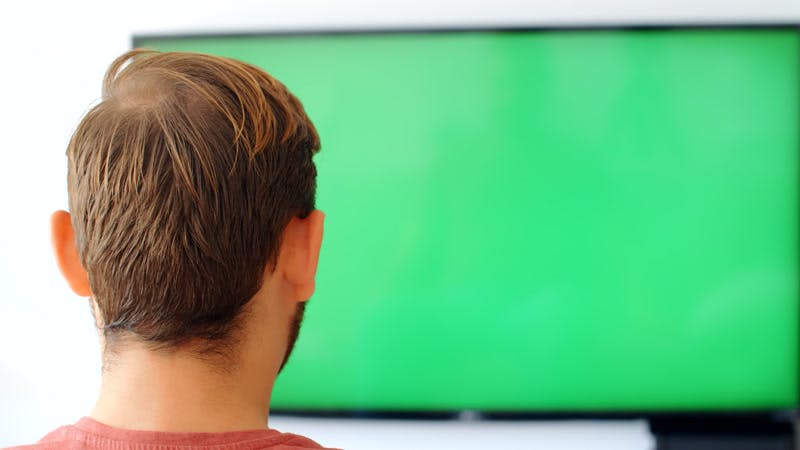 man jumping and cheering in front of a TV green screen