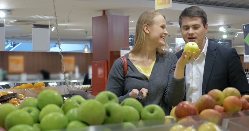 couple choosing apples in the supermarket 