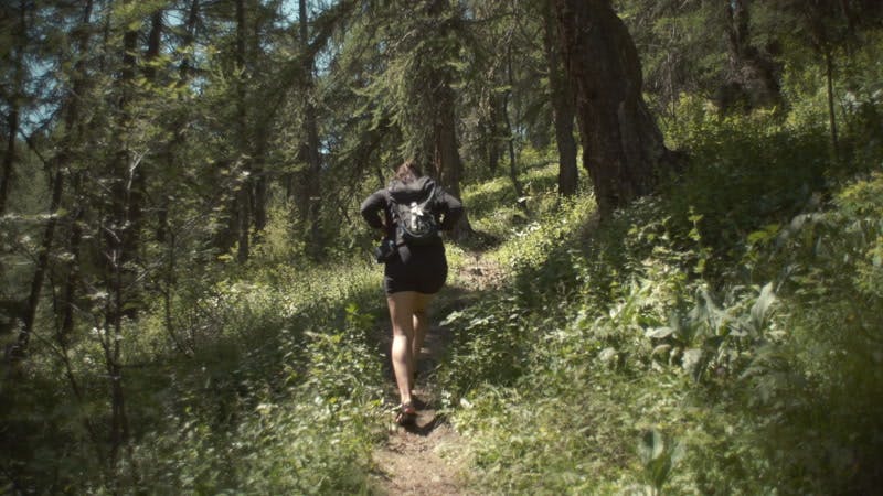 Woman hiking uphill on a forest path