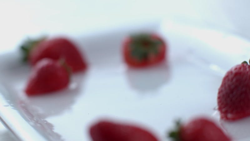 strawberries falling into a dish with water