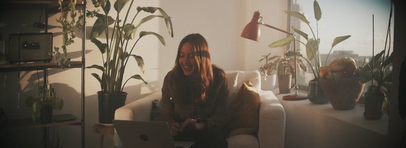 woman smiling while looking at her laptop 
