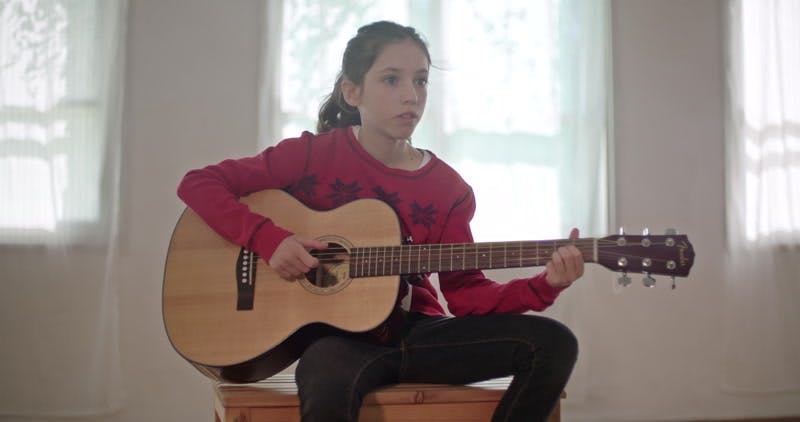 girl playing on her guitar