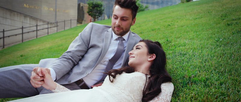 groom and bride lying on the grass together